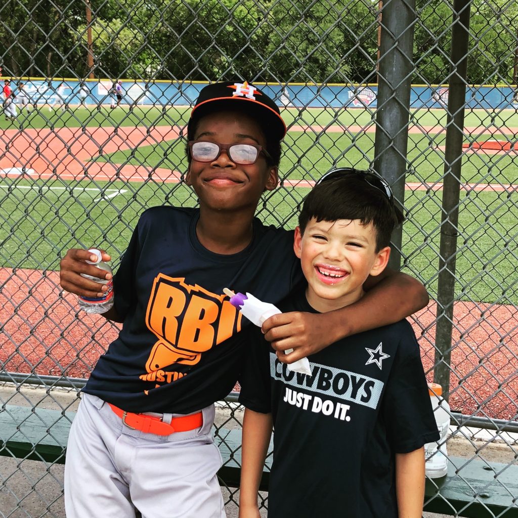 Javion and Isaiah smile after one of Javion's summer league baseball games at the RBI Austin ballpark.